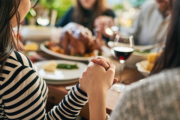 family-holding-hands-at-dinner