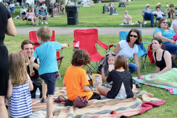 families sitting on blankets at outdoor concert